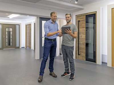 Zwei Personen in einem Beratungsgespräch und im Hintergrund Türen